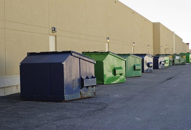 tilted front-load dumpsters being emptied by waste management workers in Beresford SD